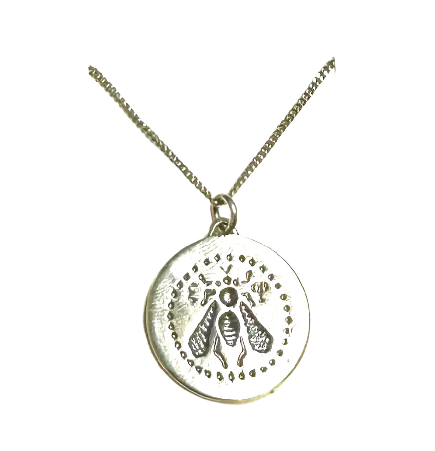 A silver necklace featuring an intaglio seal design with a queen bee motif, displayed on a white background with a branded tag.