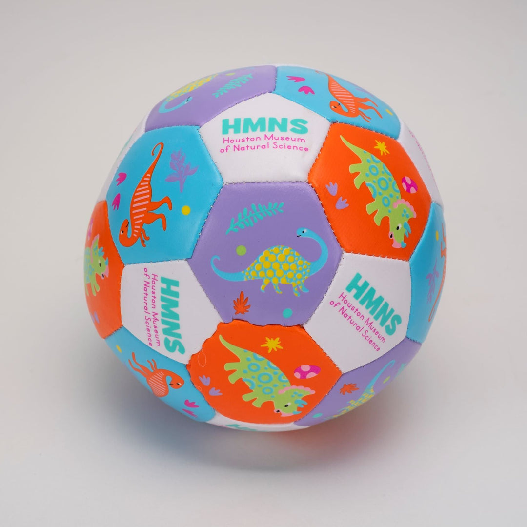 A multicolored mini soccer ball with dinosaur prints and the HMNS logo.