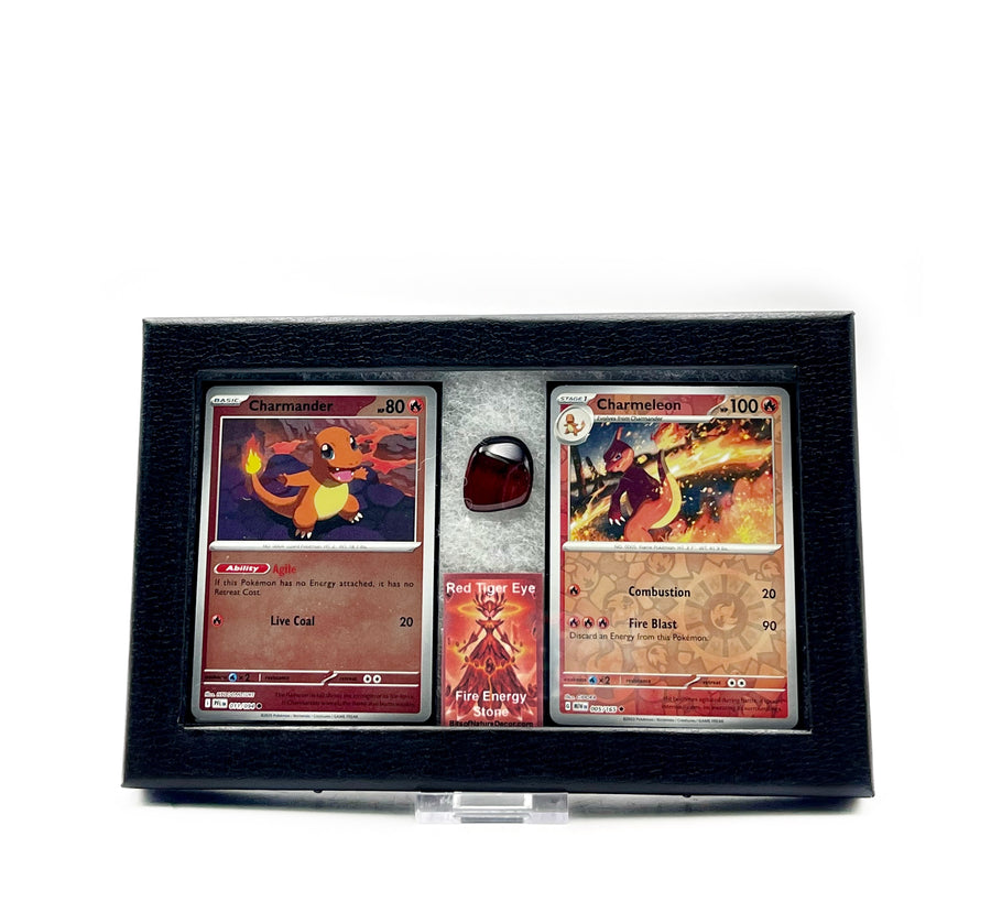 Charmander and Charmeleon Pokémon trading cards in a display case with a tumbled Tiger's Eye stone against a white background