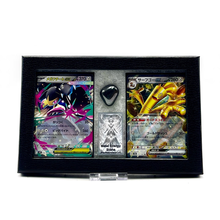 Mega Mawile and Gholdengo Japanese pokemon cards in a black box with a polished Hematite stone against a white background