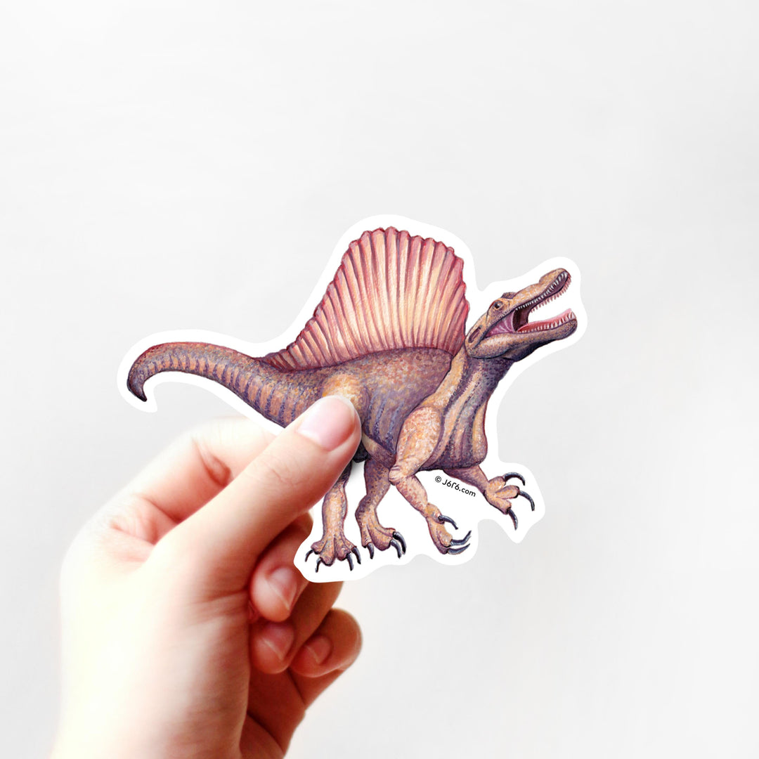 Hand holding a dinosaur sticker with a white background