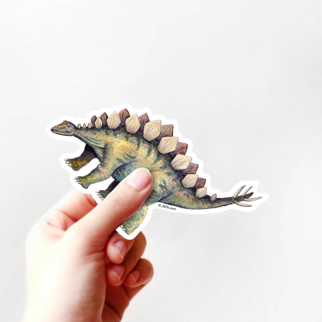 Hand holding a dinosaur sticker with a white background
