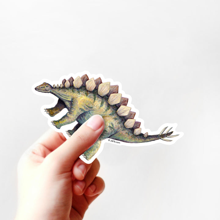 Hand holding a dinosaur sticker with a white background