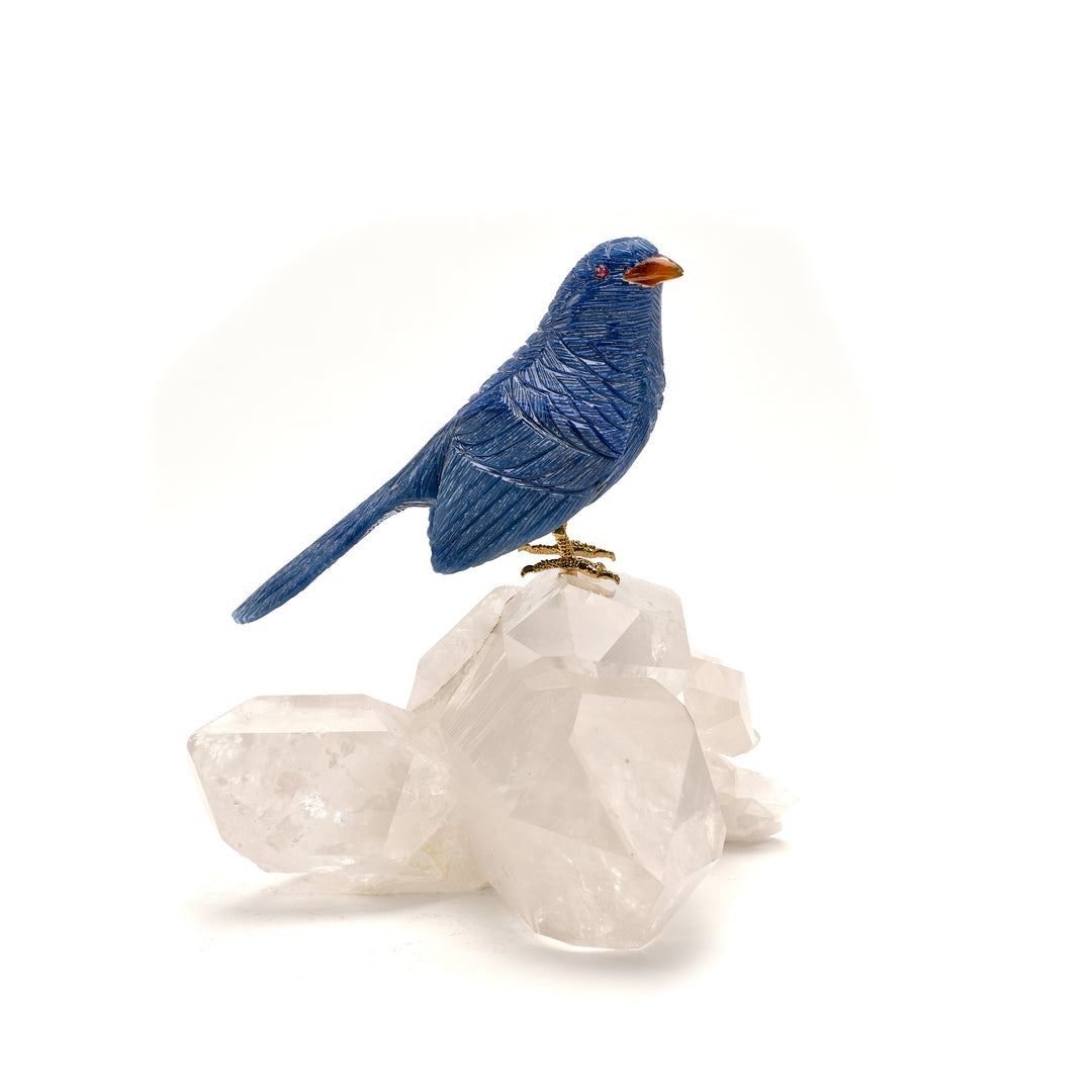 A blue Apatite Sparrow Carving on Quartz, with a Garnet eye and Agate beak, perched on a clear Quartz crystal.
