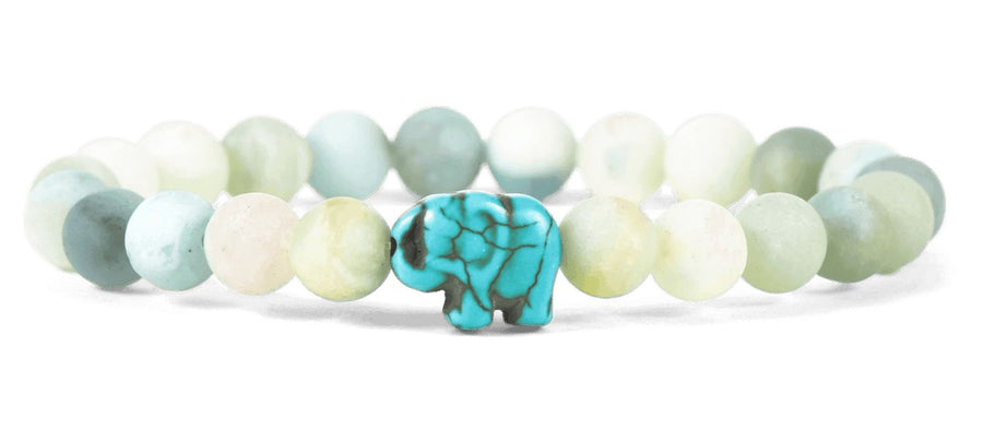light green and blue beaded bracelet featuring a dyed blue howlite
 elephant bead on white background
