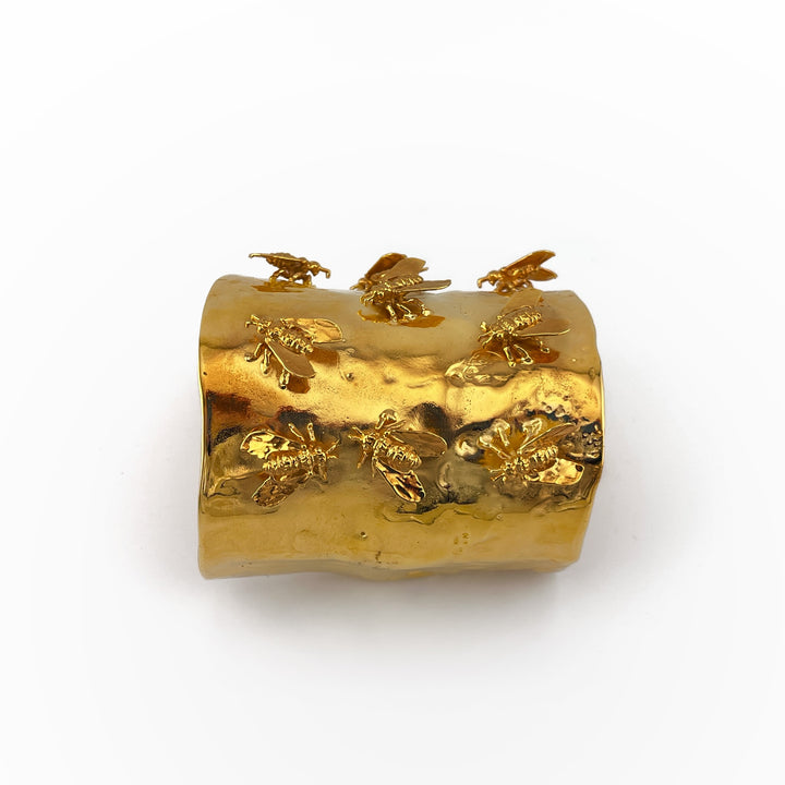 gold-tone brass cuff with nine 3D bees on it