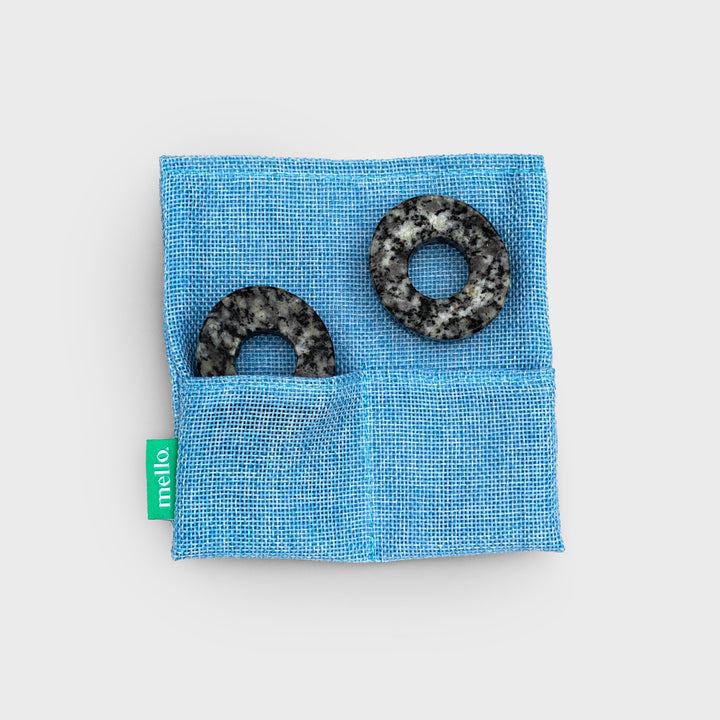 close up shot of the donut-shaped eye stones in their teal storage pouch