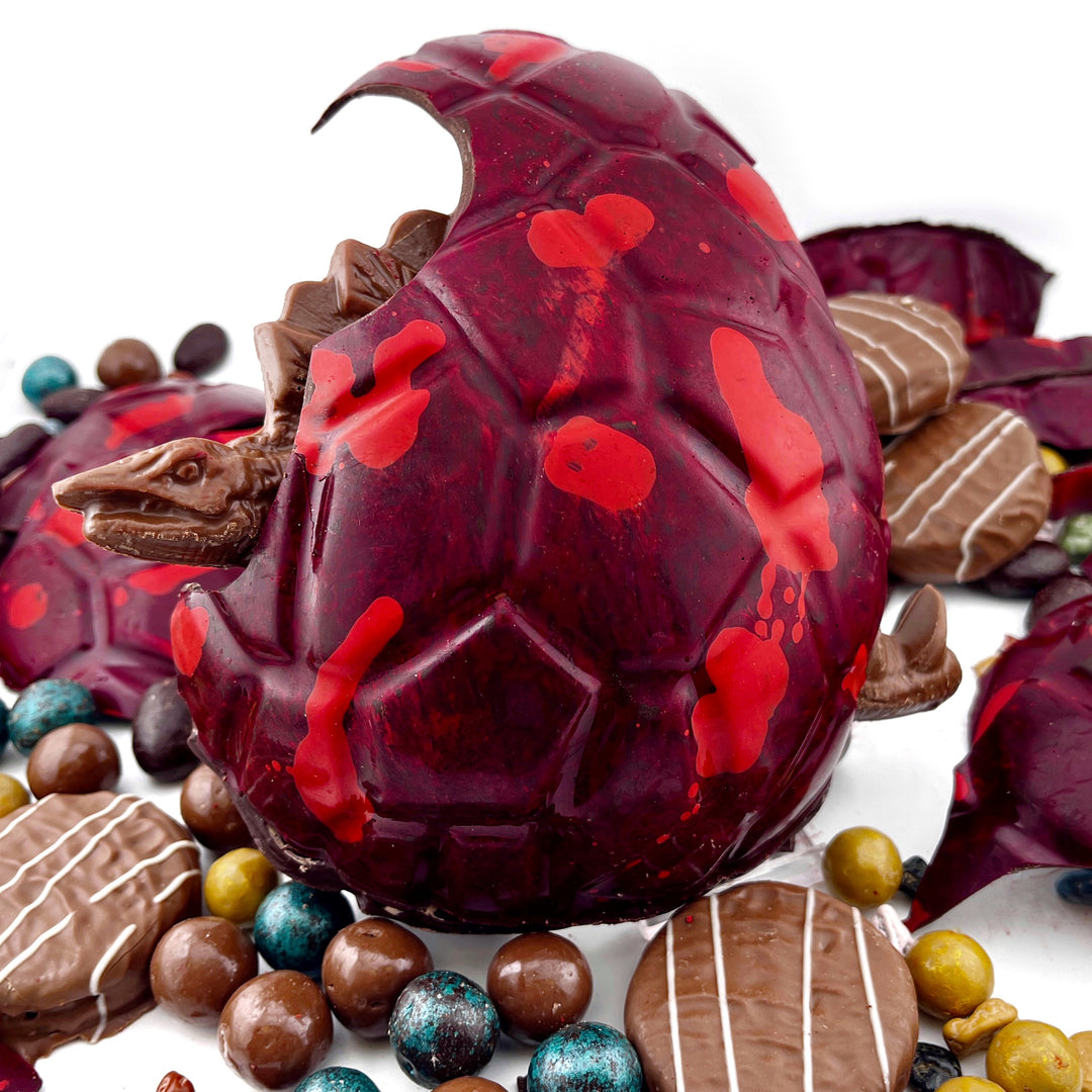 Close-up of a chocolate Easter egg with red accents on a white background