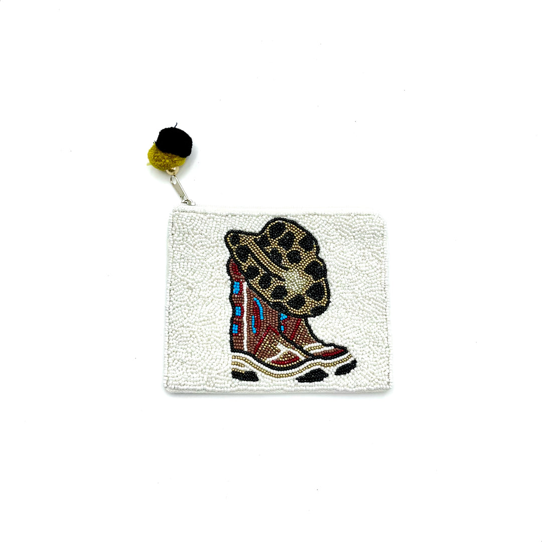 a white beaded coin purse with cowboy boots and a hat