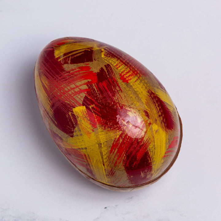 Colorful marbled egg on a white marble surface