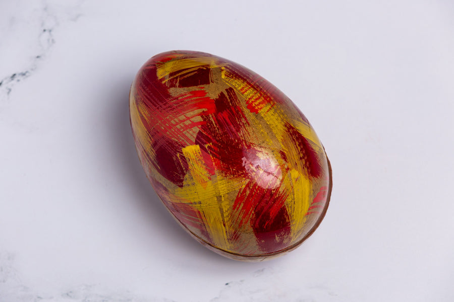 Colorful marbled egg on a white marble surface