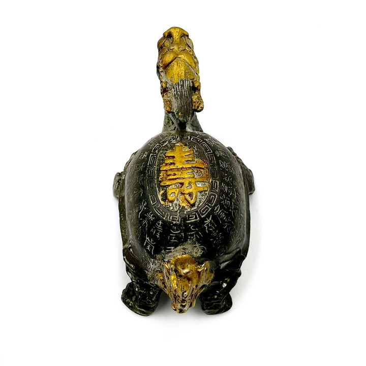 Decorative dragon turtle figurine with gold and green accents on a white background