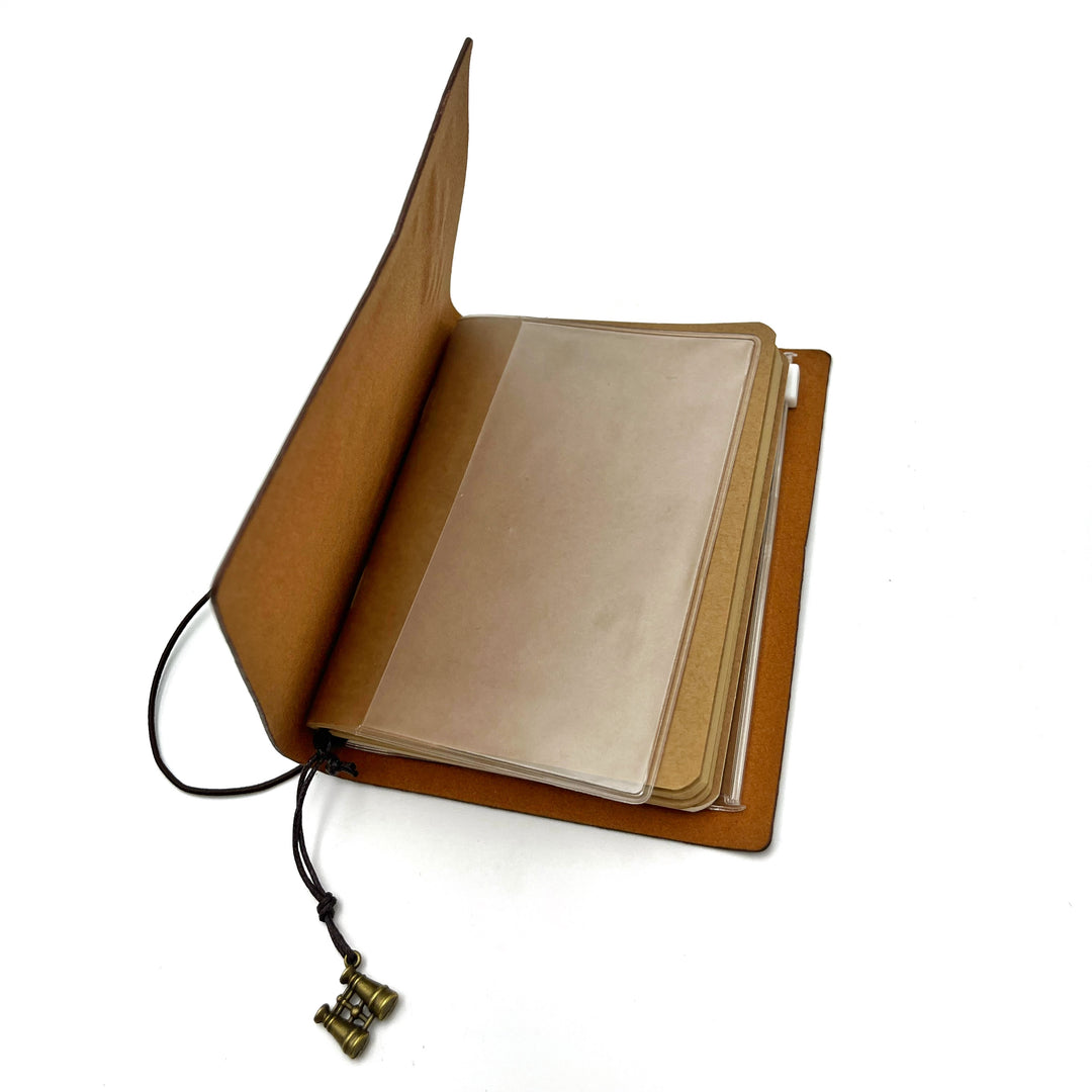 interior shot of the field journal, showing a plastic pocket and brown craft paper pages