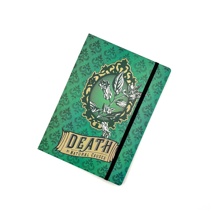 a green softbound journal featuring a poisonous plant graphic and the name of the exhibit "death by natural causes" on the cover, photographed against a white background