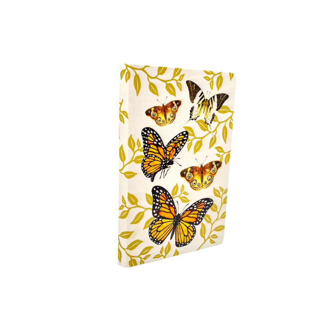orange monarch butterflies design on a cream-color journal against a white background