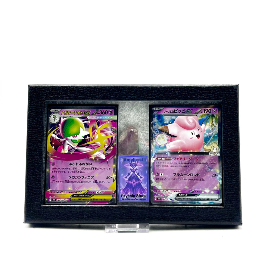 two japanese pokemon tradng cards featuring  Gardevoir and Clefairy, with a tumbled amethyst stone in a black framed collectors box against a white background