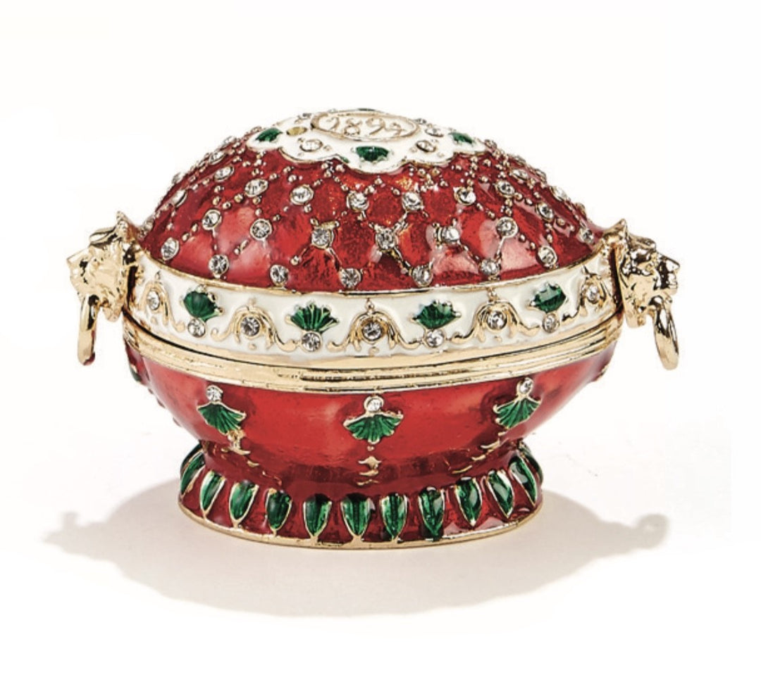 Decorative red egg with gold and green accents on a white background
