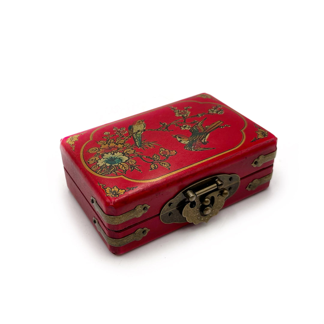 Red decorative box with gold floral and bird patterns on a white background