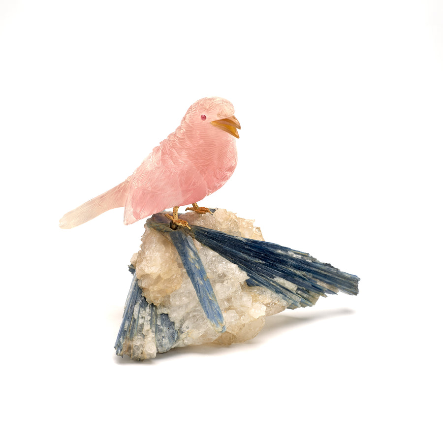 A rose quartz wren carving with garnet eyes and agate beak, mounted on a kyanite and quartz base.