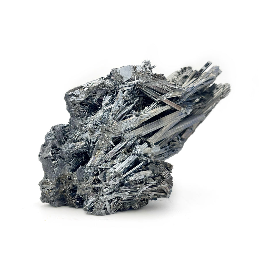 A rough, metallic stibnite mineral with a distinctive layered crystal structure against a white background.