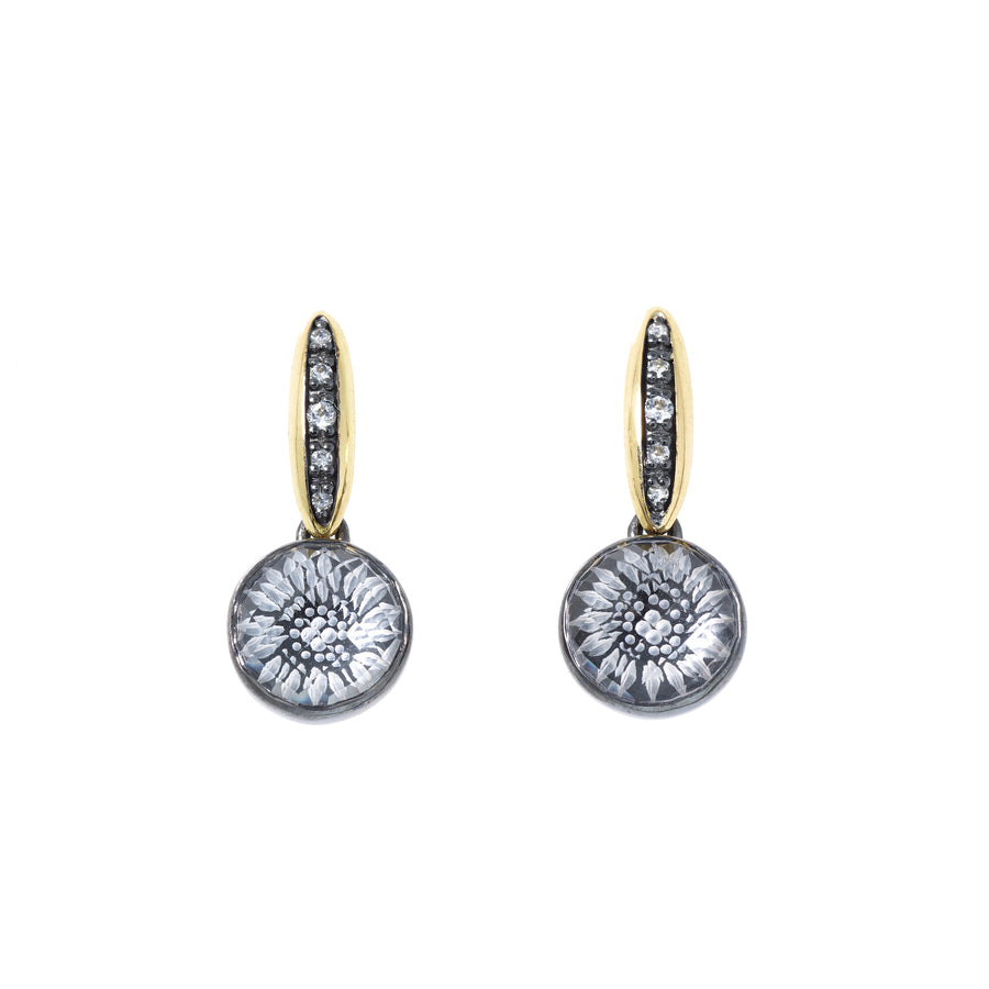 A pair of earrings featuring white topaz and rock crystal engraved floral designs, with black enamel accents, set in a gold and silver structure.