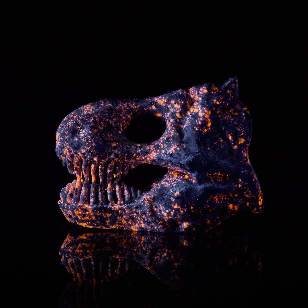 t.rex skull carving glows orange and purple under blacklight