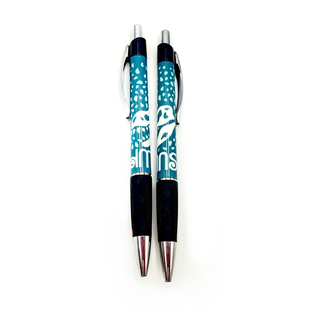 teal ballpoint pen with white dinosaur and polka dot decals