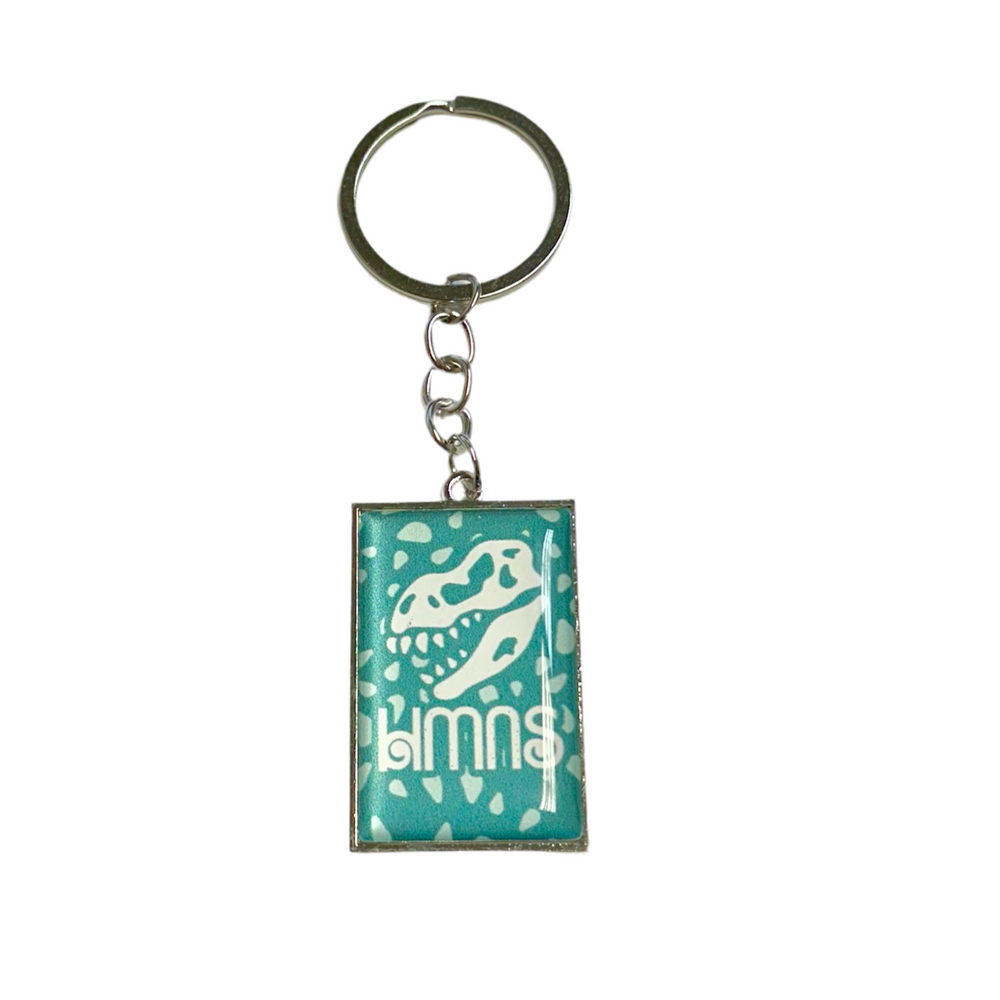 teal keychain with white dinosaur skull and decals