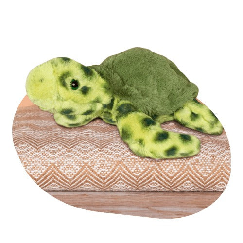 a green sea turtle plush shits on an orange patterned cushion