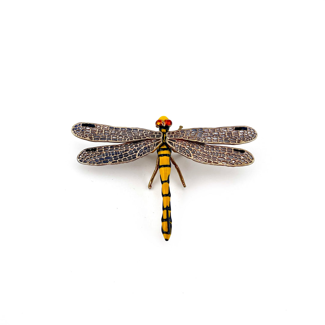 Dragonfly-shaped brooch with intricate design on a white background